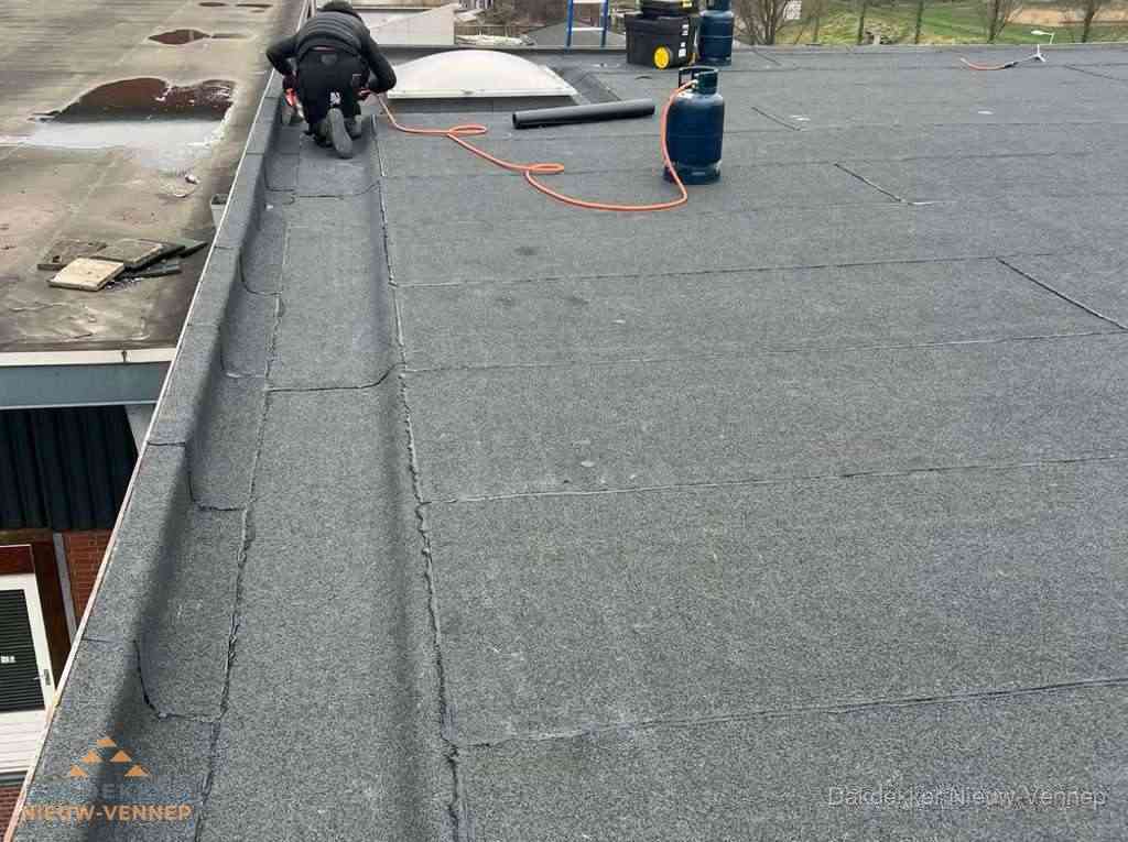 Dakdekker repareert bitumen dakbedekking op groot plat dak in Nieuw-Vennep Dakdekker repareert bitumen dakbedekking op groot plat dak in Nieuw-Vennep